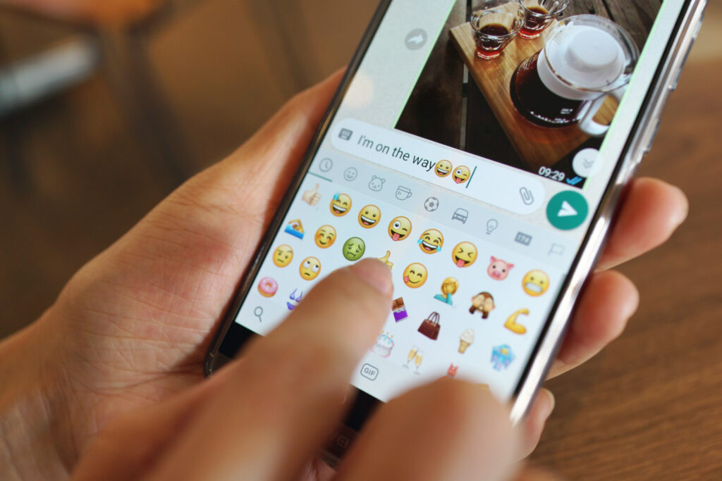 Girl sending message on WhatsApp using emojis