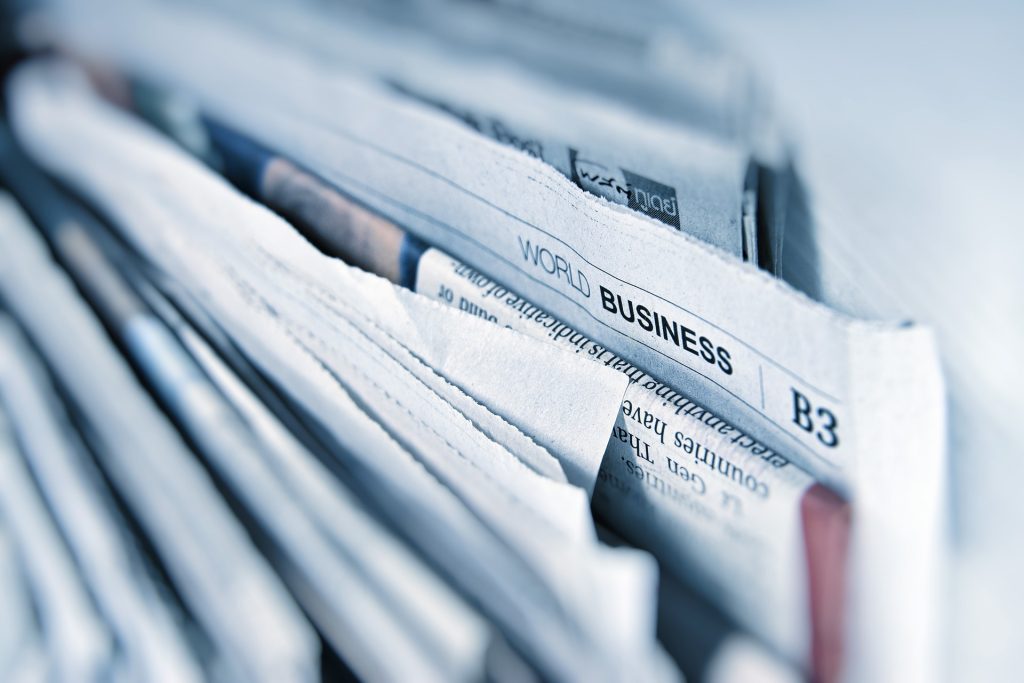 Pile of newspapers showing top tier news research