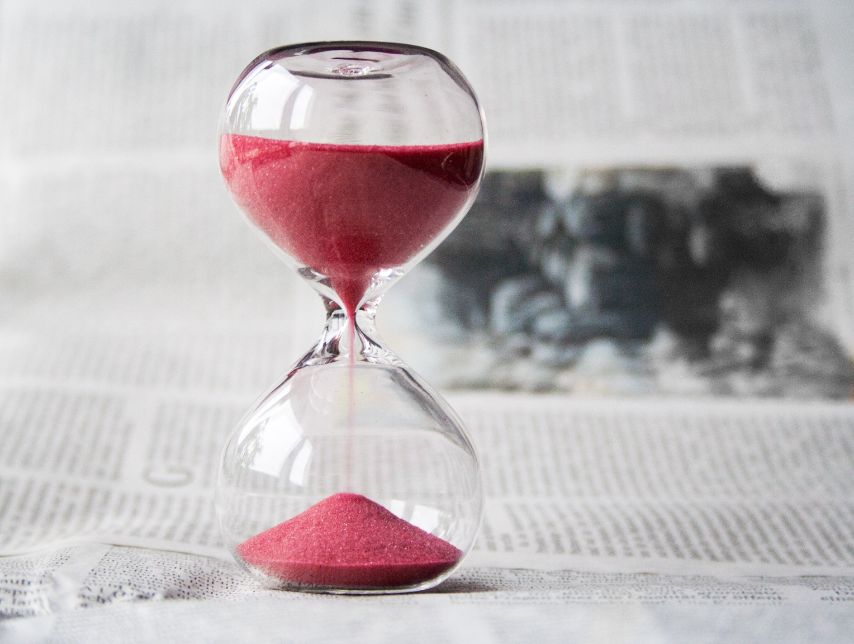 An hourglass filled with red sand.