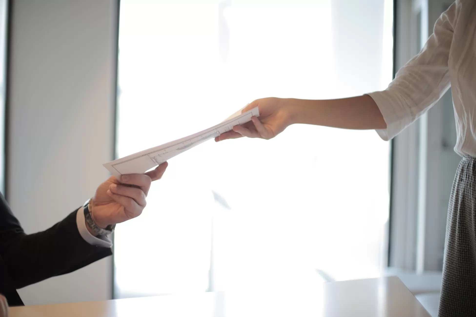 Hands reaching a document to each other